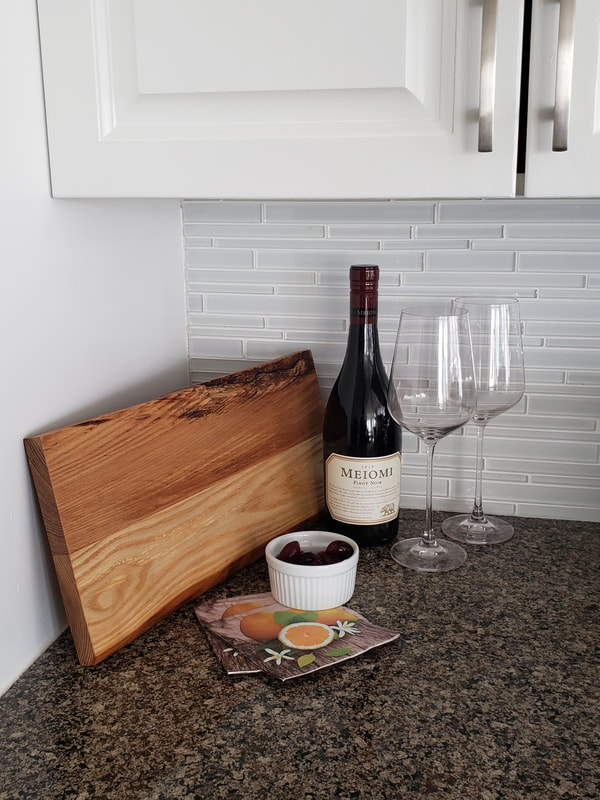 live edge charcuterie board displayed with wine and olives
