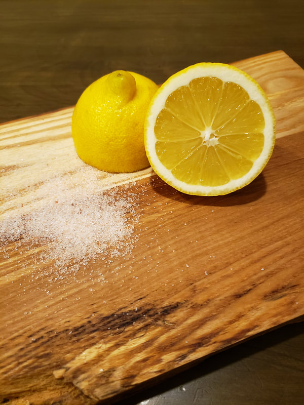 close up of live edge cutting board with lemon and salt (used for maintenance)